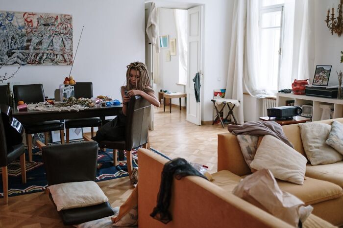 A woman in a lavish apartment highlights the disconnect of rich people from everyday reality and common living spaces.
