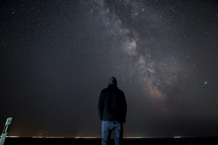 Person standing under a starry night sky looking up at the Milky Way representing things that shocked people after prison.