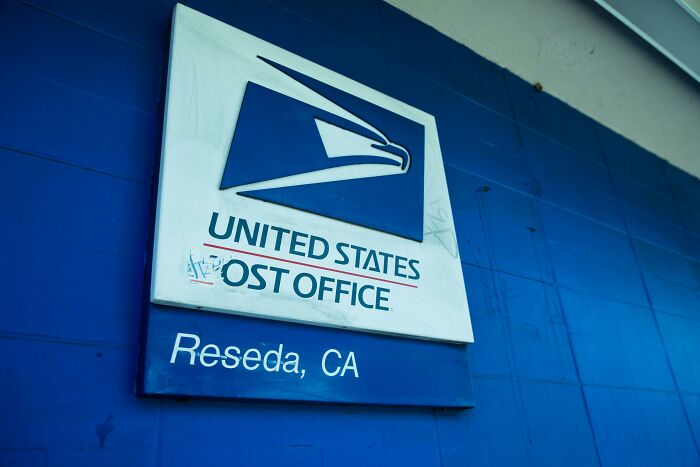 United States Post Office sign in Reseda, CA, highlighting pressing issues affecting America’s postal services.