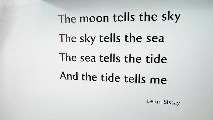 Text on a wall displaying a poetic phrase about the moon, sky, sea, and tide, relevant to linguistic geniuses and commonly confused words.