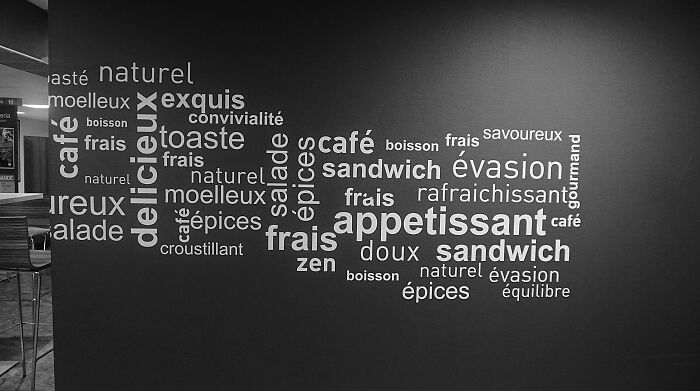 Wall art displaying French food-related words illustrating terms with different meanings across fields, helping avoid confusion.