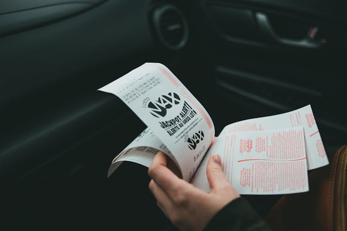 Teen holding receipts inside a car, representing spending money on herself with stepsister's support.