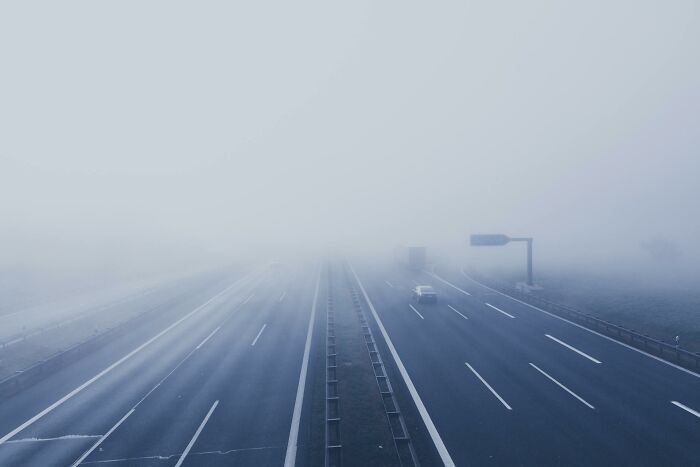 Empty multilane highway fading into dense fog, illustrating mysterious and lesser-known facts about these countries.