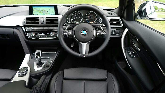 BMW car interior with luxury features and navigation screen, illustrating wealth and out of pocket rich people statements.