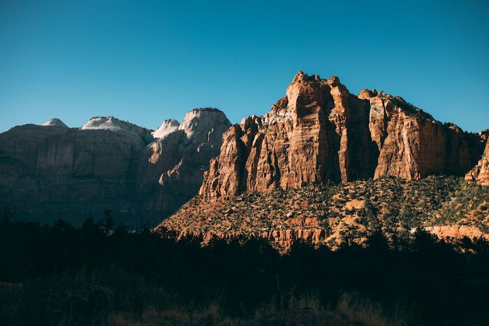 Rocky mountain landscape under clear blue sky, highlighting lesser-known facts about these countries' natural beauty.
