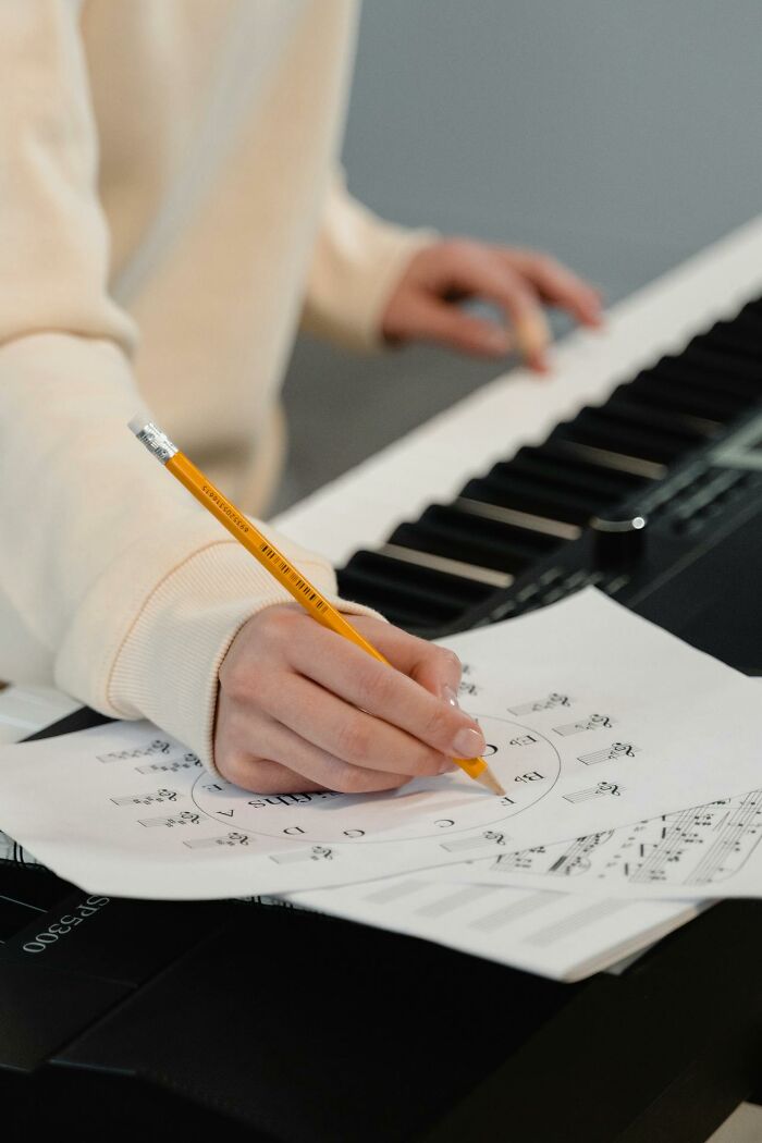 Hand writing notes on a music chart at a keyboard, creepiest displays of intelligence theme
