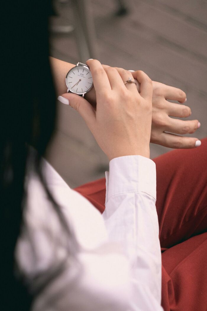 Woman wearing a luxury watch and ring, illustrating how rich people show how far from reality they are.
