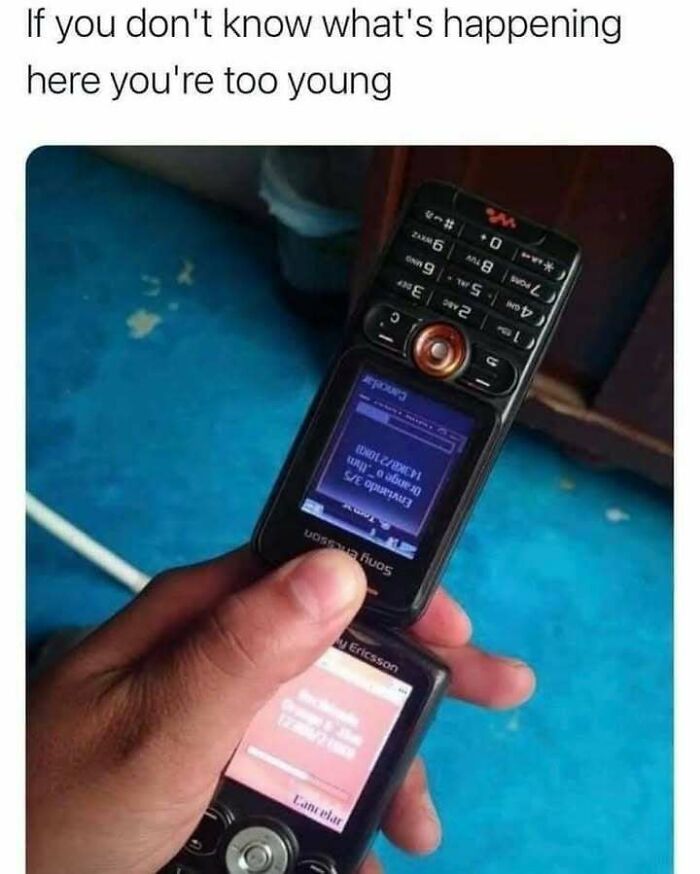 Hand holding two vintage Sony Ericsson flip phones with a caption referencing the Eastern European experience humor humorously.