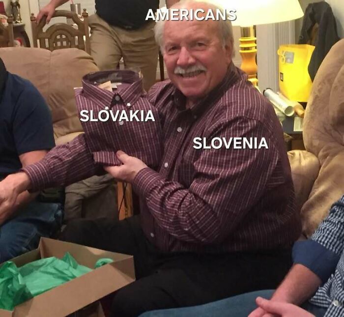 Man wearing striped shirt labeled Slovenia holds matching folded shirt labeled Slovakia with text Americans above, humor in Eastern Europe.