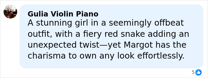 A woman wearing a bathing suit with sleeves featuring a fiery red snake design in a bold, offbeat style.