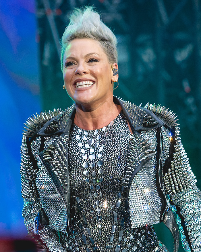 Pink smiling on stage wearing a studded outfit, breaking silence after spending New Year&rsquo;s Eve alone in hospital.