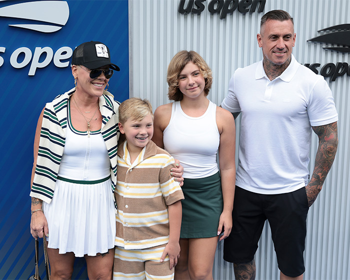 Pink with family at US Open, smiling and dressed in casual summer outfits, attending a tennis event together.