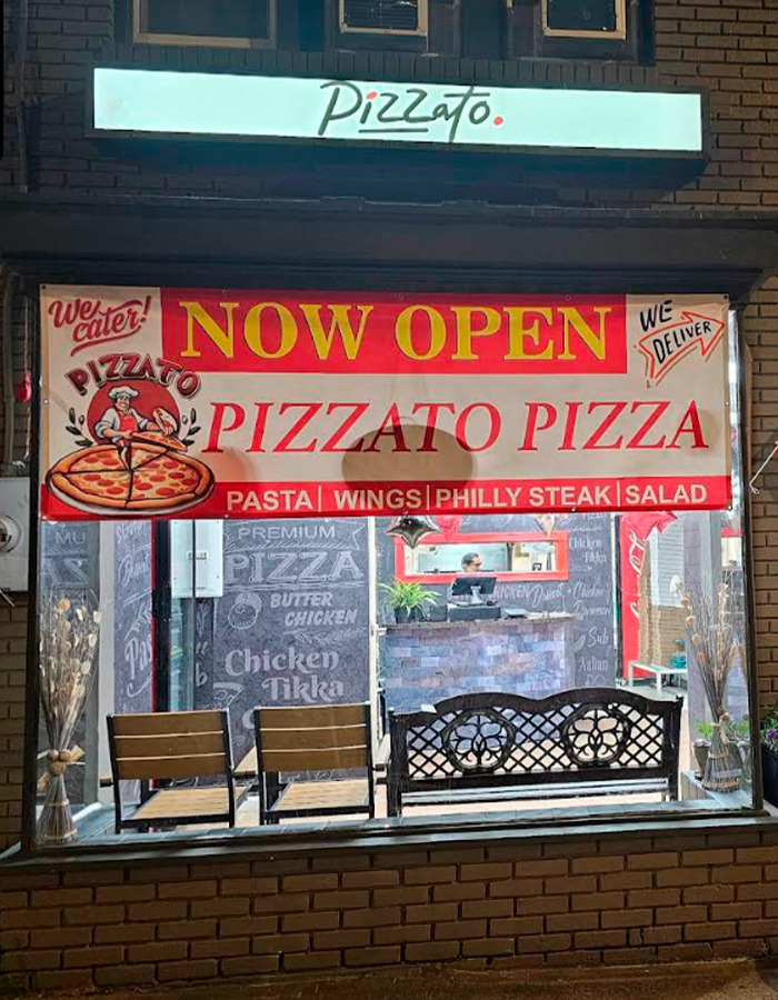 Pizzato Pizza restaurant storefront with now open banner, advertising pasta wings philly steak salad and delivery options.