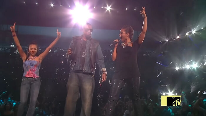 Three performers on stage during a live concert, highlighting a pop culture moment that made people cringe hard.