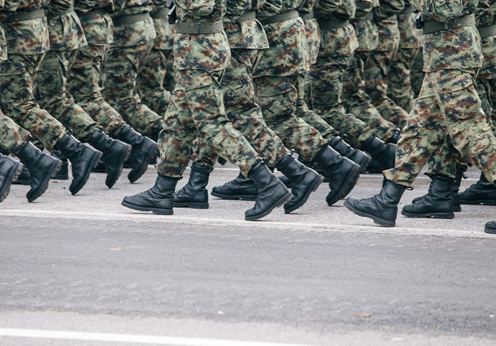 Soldiers in camouflage uniforms marching in formation, illustrating professionals sharing insights about their jobs.