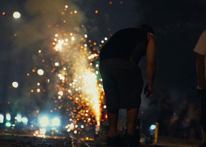 Person lighting fireworks at night, illustrating insights from professionals about what the general public doesn’t know about jobs.
