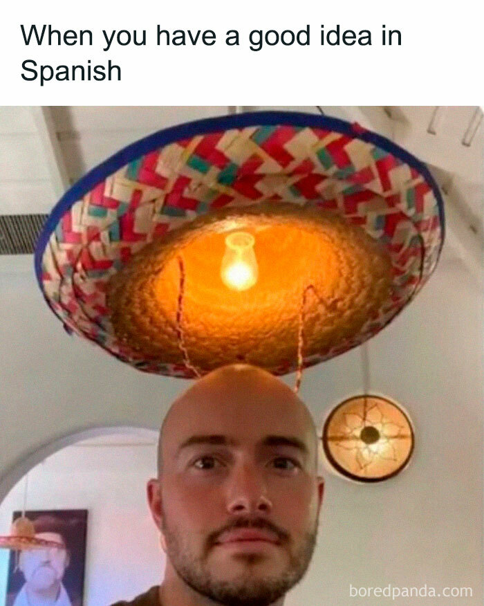 Man wearing a sombrero styled like a lampshade with a light bulb inside, a funny meme that makes no sense.