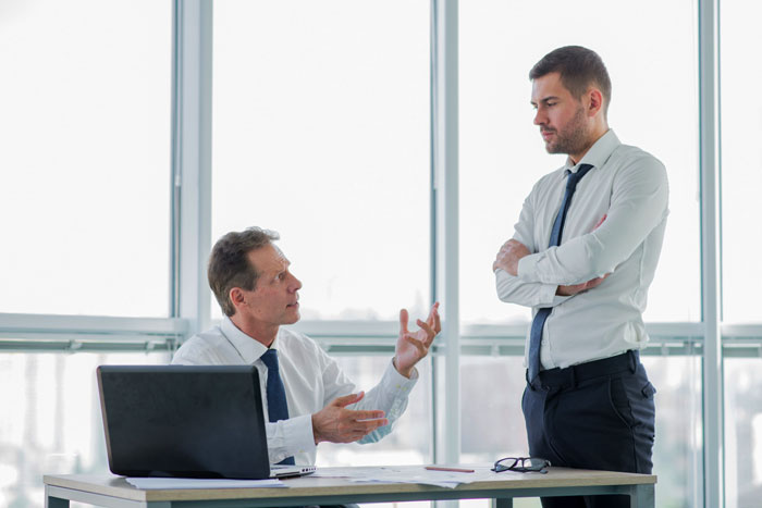 Two coworkers in office, one trying to shame the other into donating PTO while he keeps counting his days.
