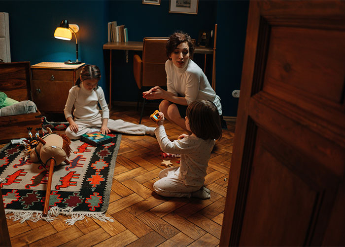 Woman in labor with kids at night, upset neighbor refuses to take children at 3am in a dimly lit room.