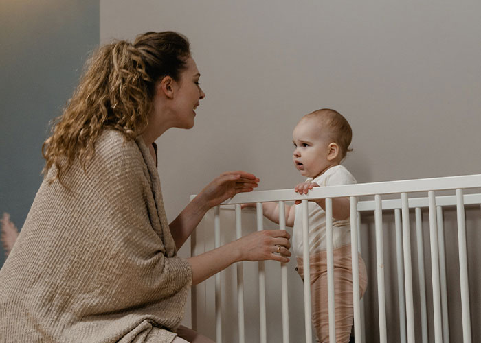 Woman in labor talking to baby in crib, showing frustration about neighbor not taking her kids at 3am.