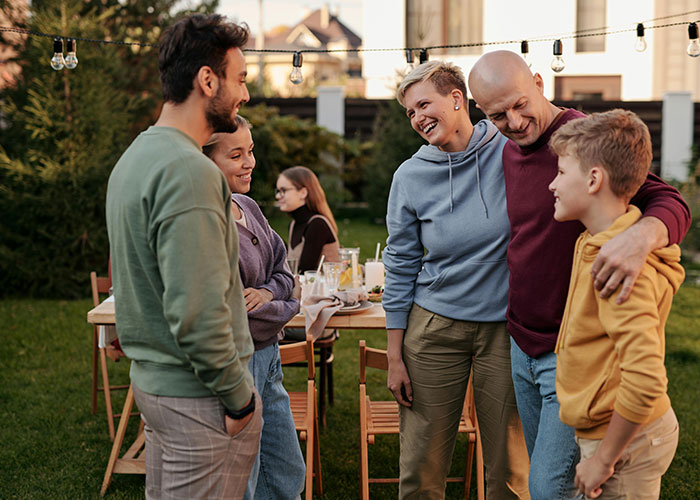 Neighbors talking outdoors in a backyard, illustrating a woman in labor upset about kids at 3am and neighborhood conflict.