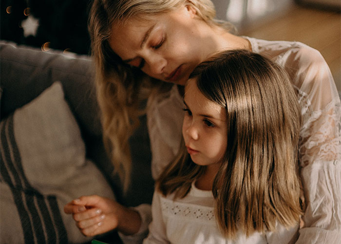 Woman in labor looking concerned while holding her child, illustrating frustration with neighbor refusing to watch kids.