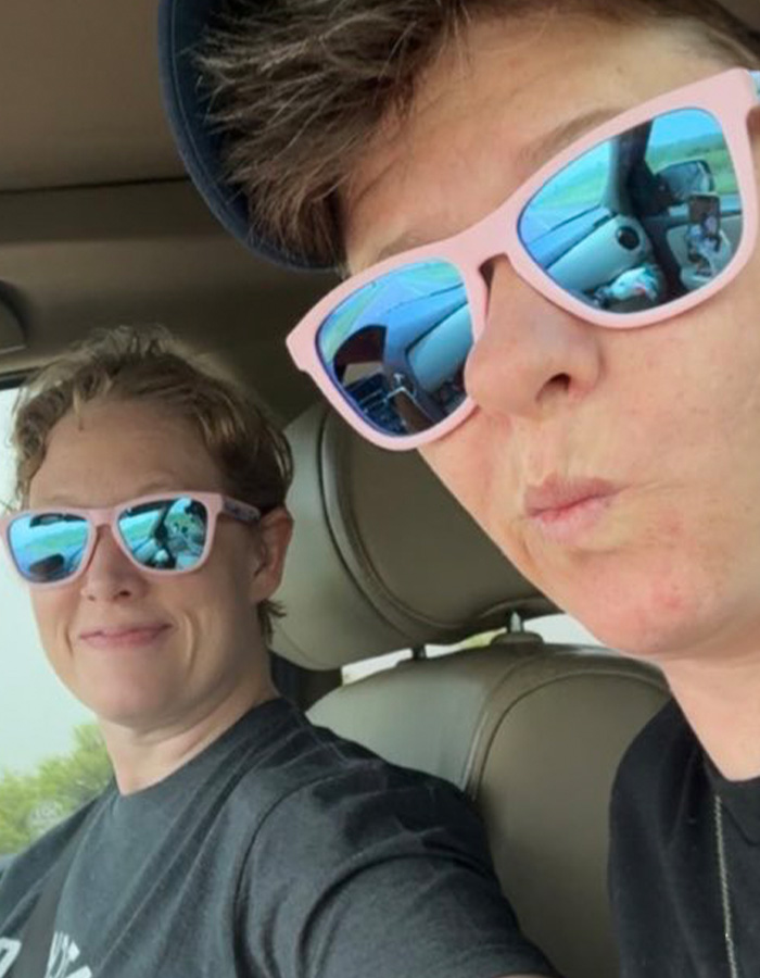 Two women wearing pink sunglasses sitting inside a car, related to Renee Good&rsquo;s wife breaking silence on fatal ICE incident.