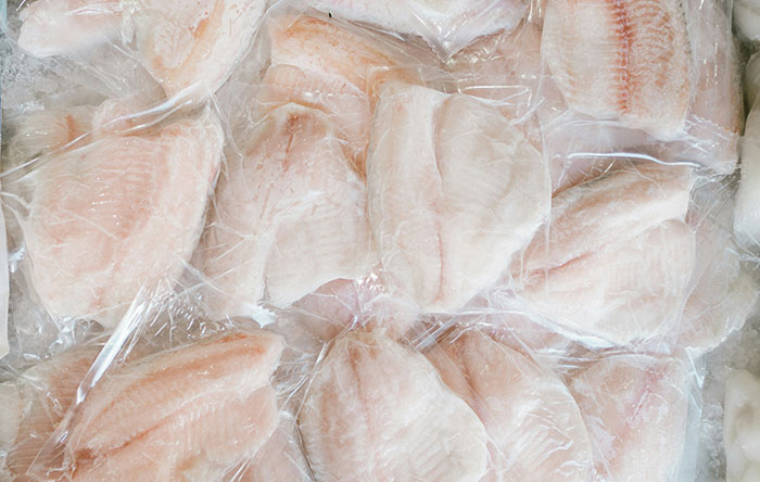 Frozen fish fillets individually wrapped in plastic, showcasing fresh seafood ready for retail or cooking.