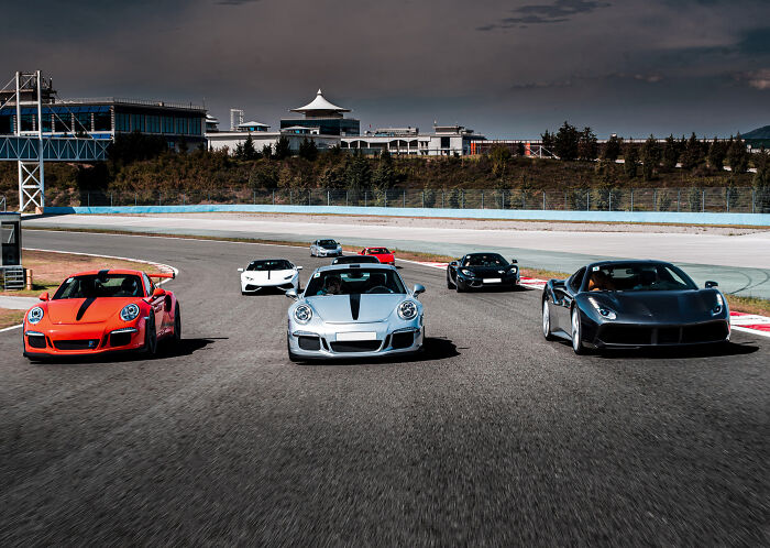 Luxury sports cars racing on a track representing the lifestyle and norms of rich people and the 1 percent.