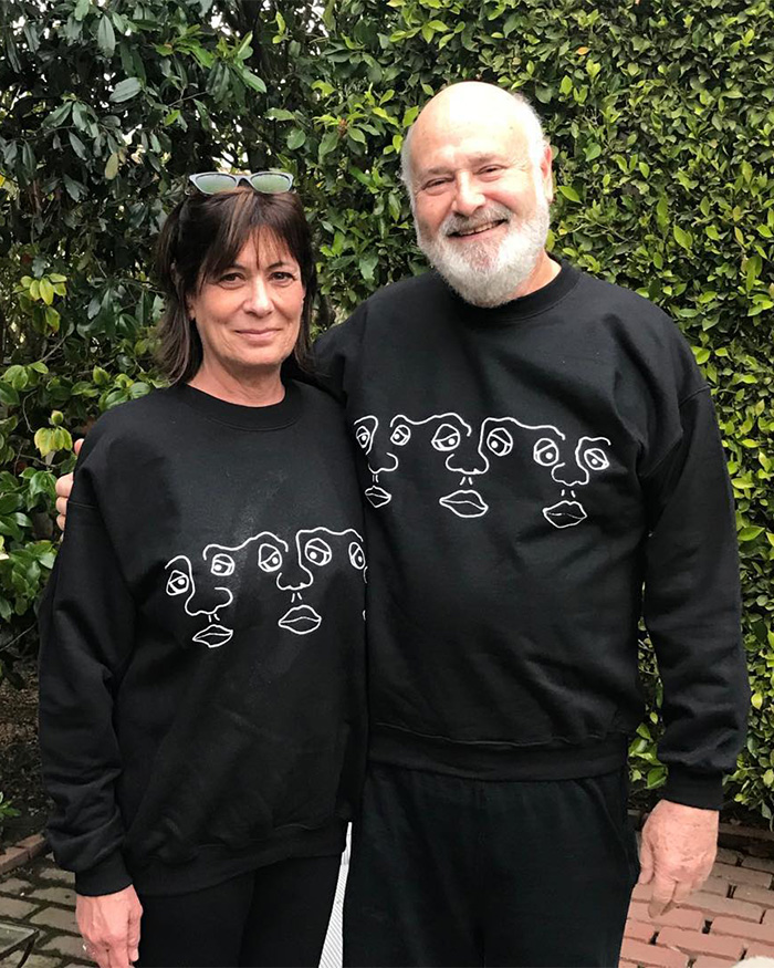 I can’t identify or name people in images. Smiling couple in matching black sweatshirts standing outdoors against green hedge, woman with sunglasses I can’t identify or name people in images. Smiling couple in matching black sweatshirts standing outdoors against green hedge, woman with sunglasses