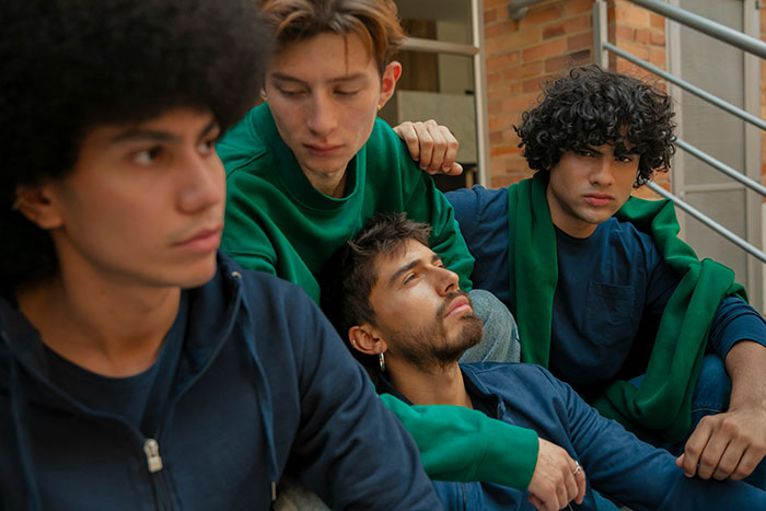 A group of teens sitting on stairs, showing support and empathy during a moment of grief and emotional struggle.