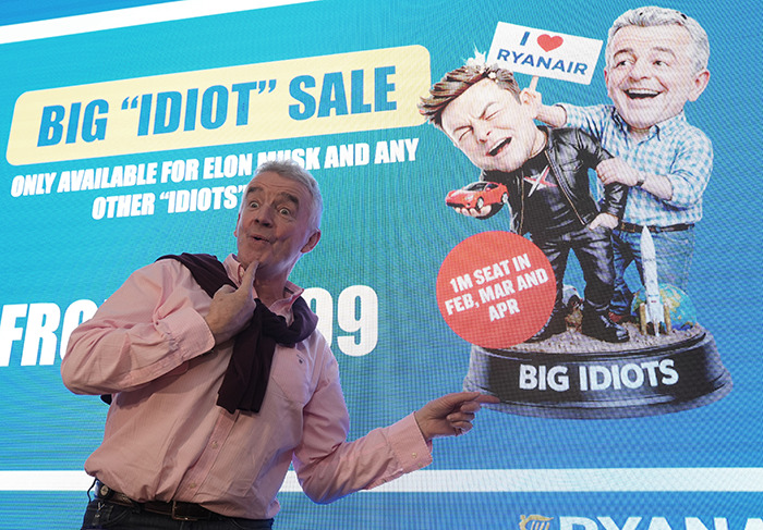 Man pointing at Ryanair's humorous caricature statue of Elon Musk, highlighting Ryanair's brutal takedown on Twitter.