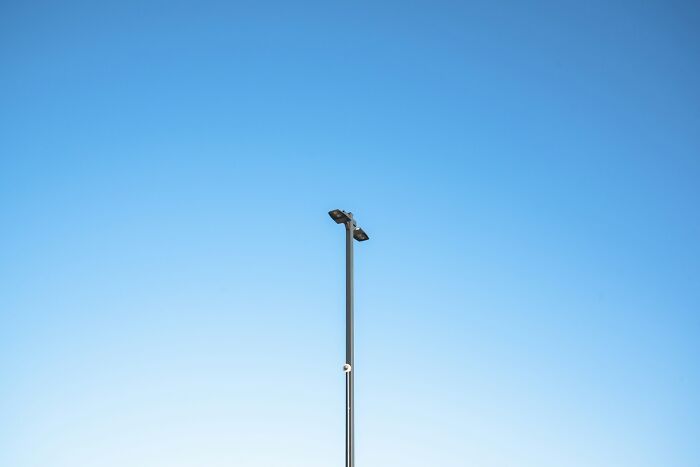 Street lamp against clear blue sky illustrating weird shocking or disturbing things people did in public with zero shame.