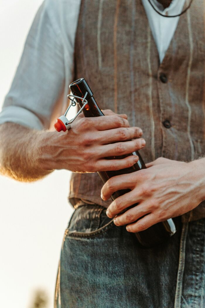 Person holding a classic European swing-top bottle showcasing normal practices in Europe that the US may find weird.