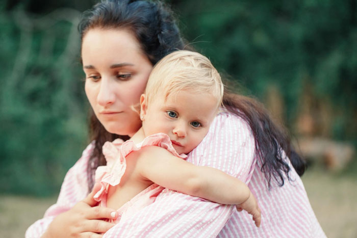 Woman comforting a grieving child outdoors, highlighting emotional support and the impact of grieving relationships.