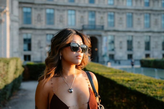 Young woman wearing sunglasses outdoors, representing cultural differences in what is normal and offensive in different countries.