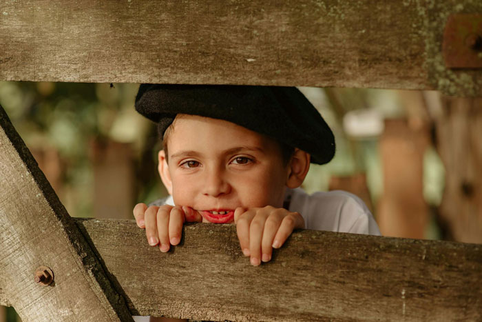 Young boy climbing wooden fence, wearing a black hat, illustrating concerns about privacy and family boundaries. Young boy climbing wooden fence, wearing a black hat, illustrating concerns about privacy and family boundaries.