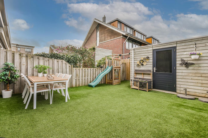 Backyard with a wooden fence and playground slide as lady ignores complaints about her son climbing fence for privacy. Backyard with a wooden fence and playground slide as lady ignores complaints about her son climbing fence for privacy.