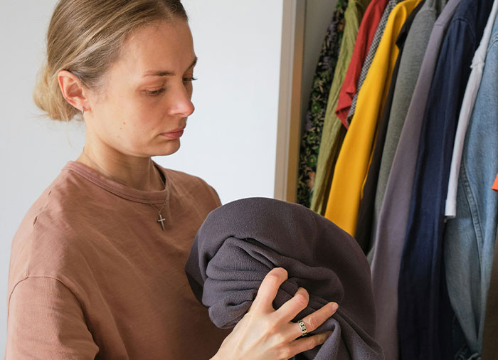 Woman folding clothes inside closet, representing a man insists his wife doesn’t do anything at home scenario. Woman folding clothes inside closet, representing a man insists his wife doesn’t do anything at home scenario.