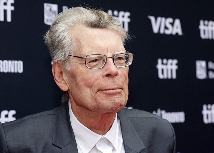 Stephen King at a film festival event, wearing glasses and a suit, facing backlash over ICE agent Jonathan Ross post.