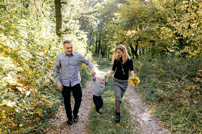 Family walking on forest path enjoying time together with stepson, discussing college and family money matters.