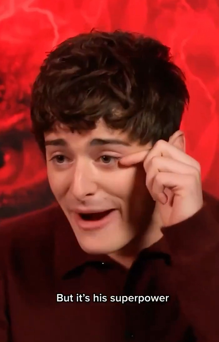 Noah Schnapp from Stranger Things speaking animatedly with a red background during an interview. Noah Schnapp from Stranger Things speaking animatedly with a red background during an interview.