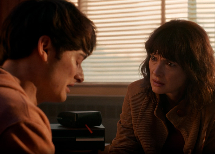 Two people having a serious conversation in a dimly lit room, relating to Stranger Things star Noah Schnapp. Two people having a serious conversation in a dimly lit room, relating to Stranger Things star Noah Schnapp.