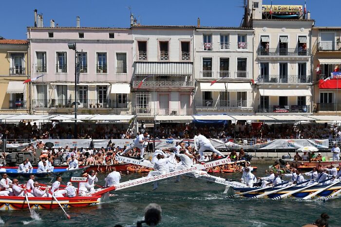 Traditional boat race with participants in white, showcasing one of the strange or unusual traditions from around the world.