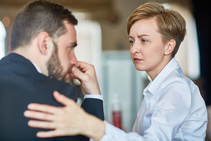 Woman comforting a man showing concern and support in a serious discussion about mil refuse baby name issues.