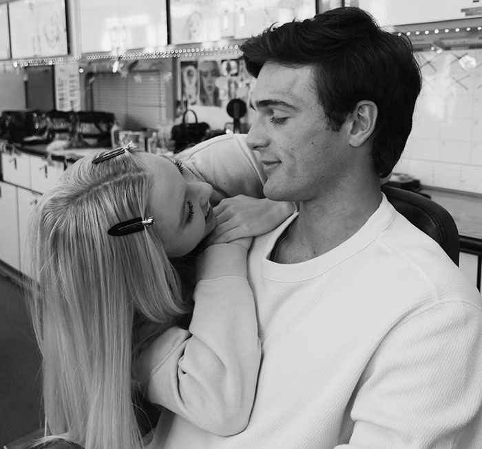 Sydney Sweeney smiling and leaning on a man in a casual indoor setting, portraying an adult star role. Sydney Sweeney smiling and leaning on a man in a casual indoor setting, portraying an adult star role.
