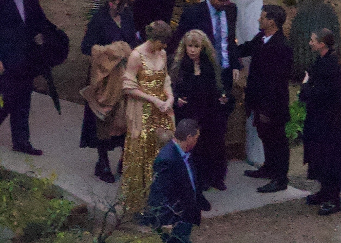 Taylor Swift in a shimmering gold dress at a friend's wedding, sparking fans' scrutiny over her look.