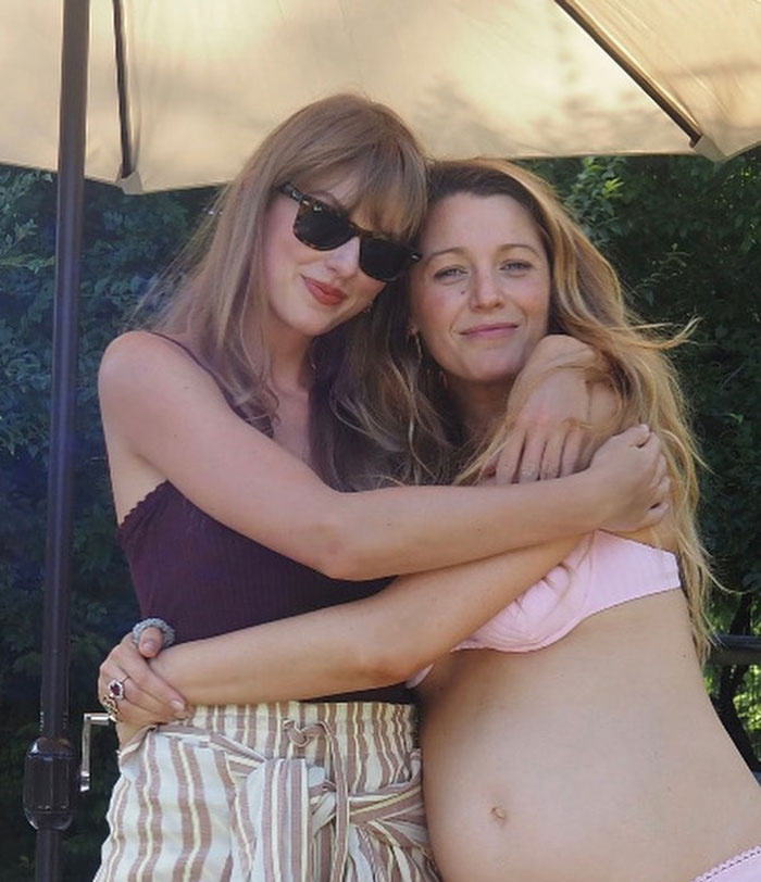 Two women embracing outdoors under an umbrella, highlighting Blake Lively and Ryan Reynolds's texts about Justin Baldoni case. Two women embracing outdoors under an umbrella, highlighting Blake Lively and Ryan Reynolds's texts about Justin Baldoni case.