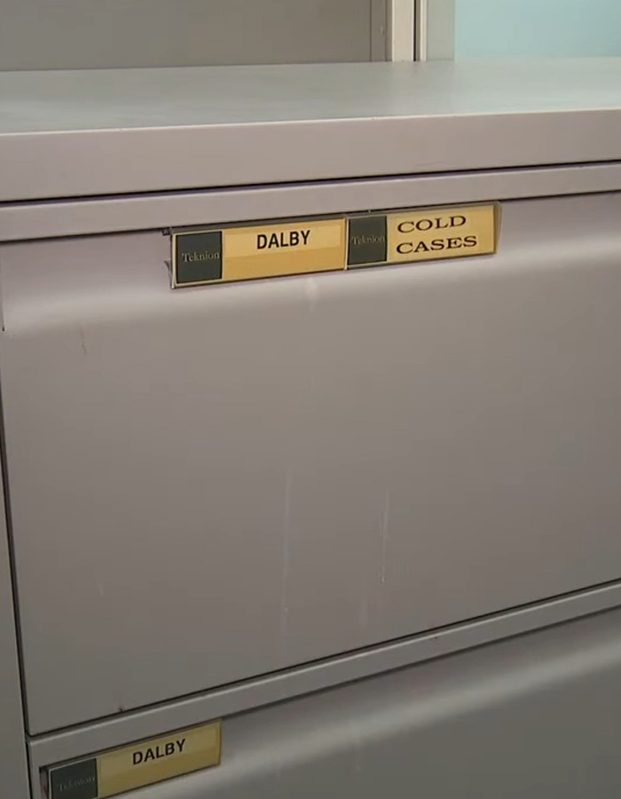 Closure file cabinet drawer labeled DALBY and COLD CASES in a gray records room Closure file cabinet drawer labeled DALBY and COLD CASES in a gray records room