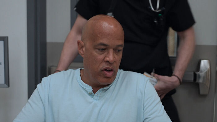 Patient in a hospital setting discussing one of the most realistic medical cases from the Pitt with a healthcare professional.